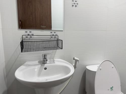 a white bathroom with a sink and a toilet at Live like a local Homestay in Ấp Tư Tây