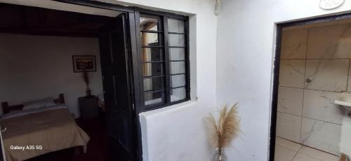 a door with a window and a feather on it at Hostel El Tambo in Ollantaytambo