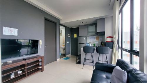 a living room with a couch and a flat screen tv at Palam Mansion at Apartment One Residence in Batam Center
