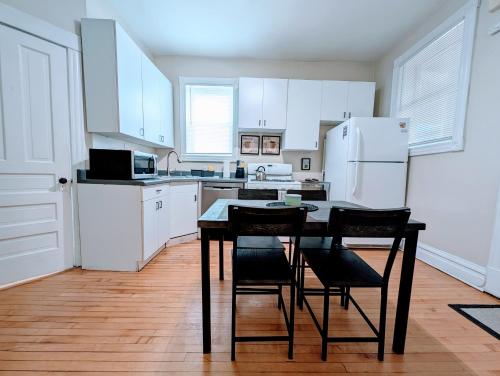 a kitchen with white cabinets and a table and chairs at The Roscoe Village Guesthouse in Chicago