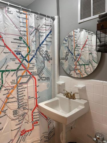 a bathroom with a sink and a shower curtain with a map at Downtown Boston Common Studio Theater District Chinatown Smart HDTV TD Garden Bruins Celtics Patriots in Boston
