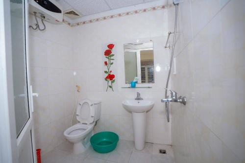 Un baño blanco con inodoro y lavabo. en Khách Sạn Hoàng Minh, en Sầm Sơn
