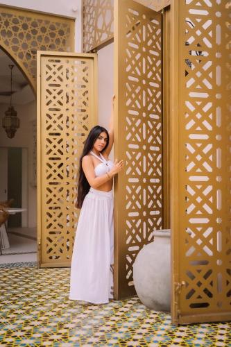 a woman in a white dress standing in front of a door at Sana Tulum Beachfront Boutique Hotel in Tulum