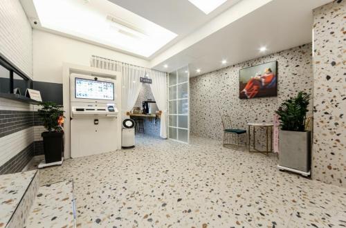 an office with a large room with a tv and a wall at Gwangju Yeogijoa Hotel in Gwangju