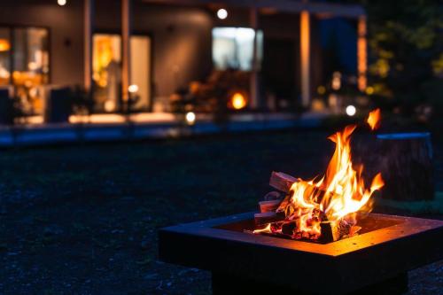 a fire pit in front of a house at night at enico Mt Fuji ラグジュアリーテント Tourmarine in Narusawa