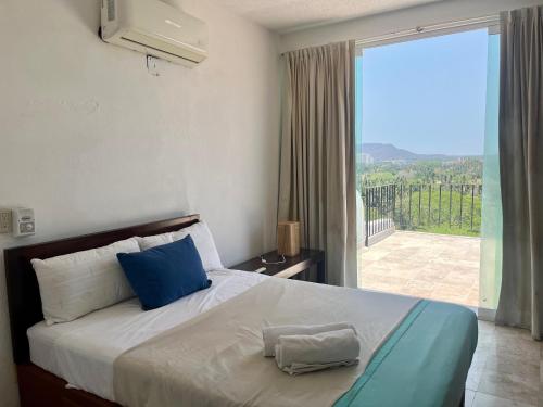 a bedroom with a bed and a large window at Casa Paloma in Ixtapa