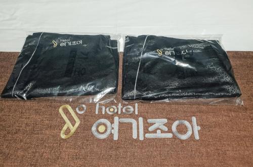 a pair of black pants sitting on top of a bed at Gwangju Yeogijoa Hotel in Gwangju