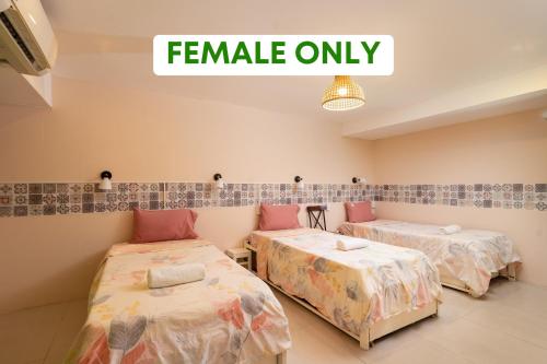 a room with two beds and a sign that reads female only at HY Local Budget Hotel - 5 mins walk to Hoi An Ancient Town in Hoi An