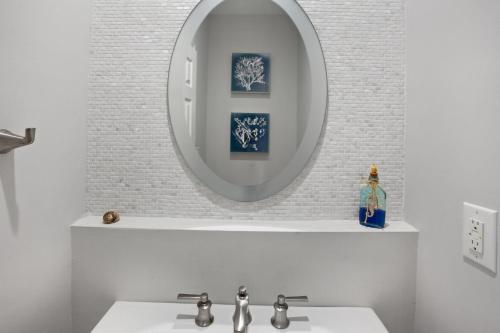 a bathroom with a sink and a mirror at 3025 - Who's On First in Southern Shores