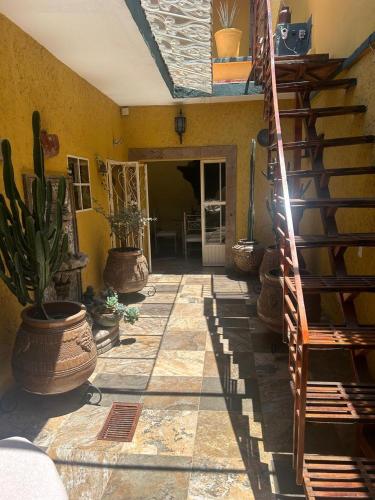 a living room with a staircase and potted plants at La Casa de Ensueño in Guadalajara