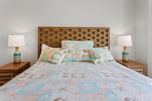 a bedroom with a large bed with two lamps at 3025 - Who's On First in Southern Shores