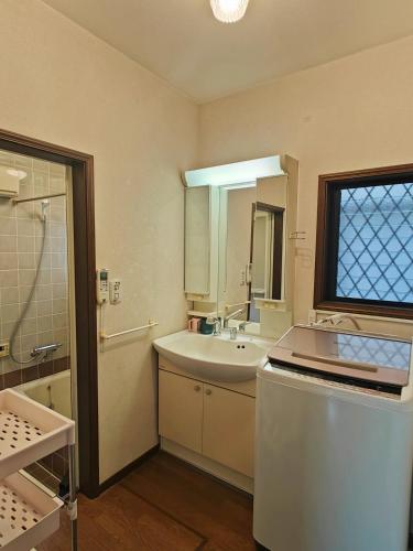 a bathroom with a sink and a shower and a mirror at Traditional 2-Story Japanese Home Near Narita in Shisui