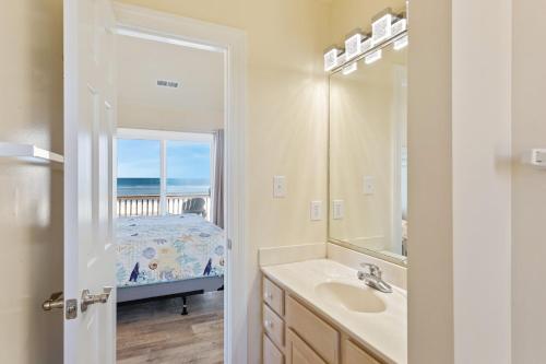 a bathroom with a sink and a mirror and a bed at 8046 - Sun Runner in Rodanthe
