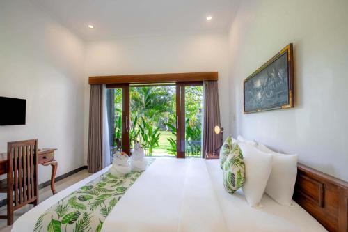 a bedroom with a bed and a sliding glass door at Carik Bali Guest House Canggu in Canggu