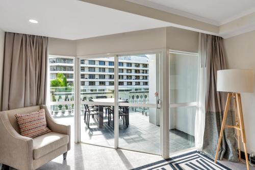 a living room with a balcony with a table and chairs at Pullman Cairns International in Cairns