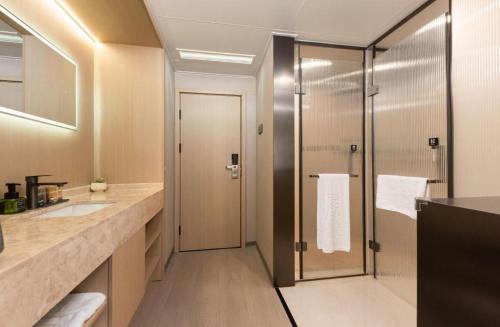 un baño con ducha y lavabo en Greatwall Hotel - Zhengzhou, en Zhengzhou
