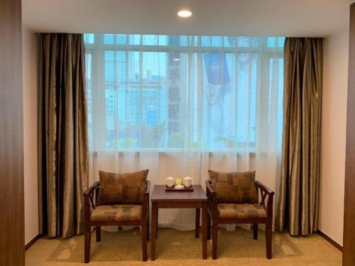 a table and two chairs in front of a large window at My Pleasant Hotel in Shenzhen