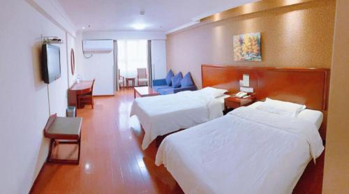 西安市にあるGreenTree Inn Xi'an Bell and Drum Tower Food Street Ancient City Wall Ximen Express Hotelのベッド2台とテレビがあるホテルの部屋
