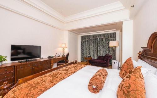 a hotel room with a large bed and a television at Zhengzhou Yiquan International Hotel in Zhengzhou