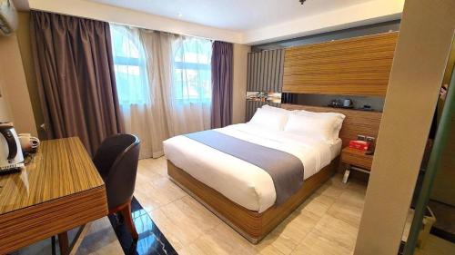 a hotel room with a bed and a desk at Hong Thai Hotel in Macau