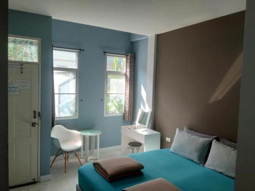 a blue bedroom with a bed and a chair at Daddy's home Huahin in Hua Hin