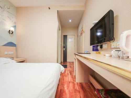 a hotel room with a bed and a flat screen tv at Super 8 Hotel Jinan Railway Station Square in Jinan