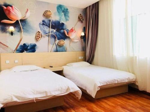two beds in a room with a painting on the wall at Super 8 Hotel Jinan Railway Station Square in Jinan