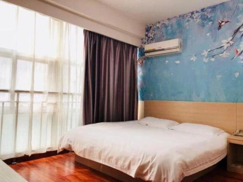 a bedroom with a bed and a blue wall at Super 8 Hotel Jinan Railway Station Square in Jinan
