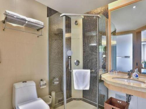 a bathroom with a shower and a toilet and a sink at Jinhua World Trade Hotel in Jinhua