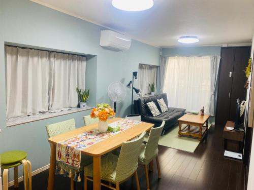 a living room with a table and chairs and a couch at Umeda Yodogawa Cozy Home A 步行到JR站5分钟 大阪梅田1站 新大阪2站 京都 神户直达 USJ地铁25分钟 in Osaka