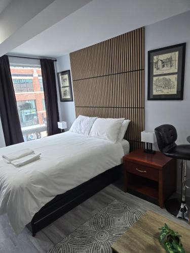 a bedroom with a bed and a chair and a window at CDQI Hotel in Ottawa