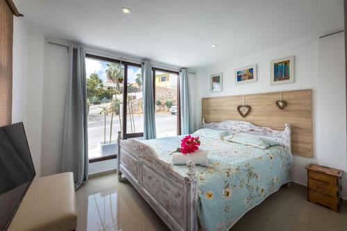 a bedroom with a bed with flowers on it at Apartment Lovely Rose with garden Jacuzzi in Jan Thiel