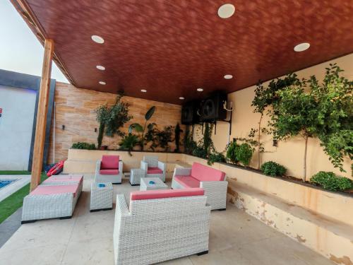 a patio with chairs and tables on a balcony at Wonder Villa in Al Rama