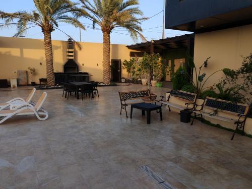 a courtyard with benches and a piano and palm trees at Wonder Villa in Al Rama