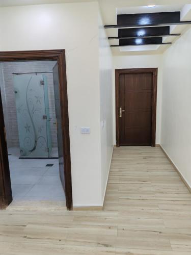 an empty hallway with two doors and a wooden floor at Wonder Villa in Al Rama