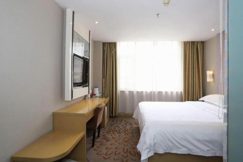 a hotel room with a bed and a desk at Lavande Hotel Yantai Train Station Branch in Yantai