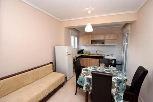 a kitchen and dining room with a table and a couch at A&G Country House, Potamos Epanomis Beach in Epanomi