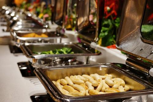 a row of trays filled with food on a buffet at Central Hotel Shanghai - Nanjing Road in Shanghai