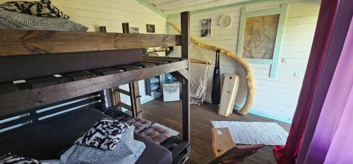 a room with a bunk bed and a couch at Lighthouse Benki in Užava