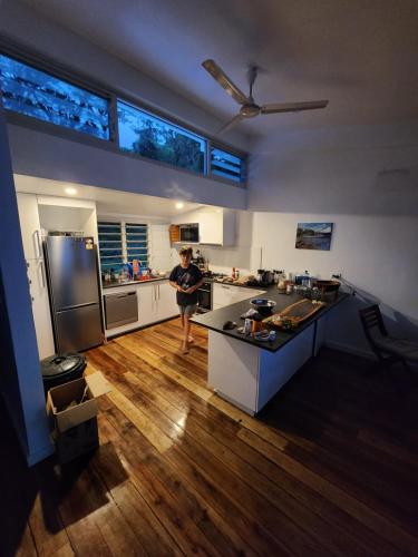 a man standing in a kitchen with a refrigerator at Waterfront modern 3br home Vale Ni Vonu in Nggathavulu