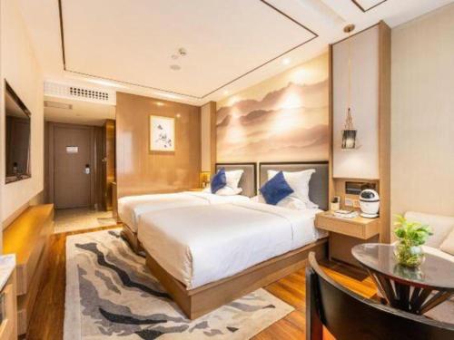 a hotel room with a large bed and a table at East Queen Hotel (Xi'an Beimen Metro Station) in Xi'an
