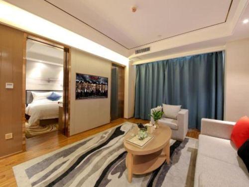a living room with a couch and a table and a bed at East Queen Hotel (Xi'an Beimen Metro Station) in Xi'an