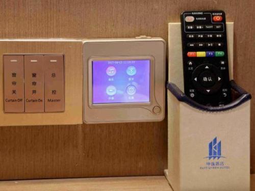 a remote control in a box next to a box at East Queen Hotel (Xi'an Beimen Metro Station) in Xi'an