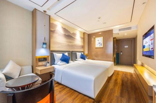 a bedroom with a large white bed and a couch at East Queen Hotel (Xi'an Beimen Metro Station) in Xi'an