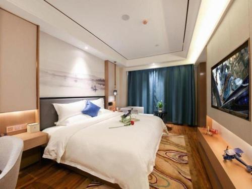 a bedroom with a large white bed and a large window at East Queen Hotel (Xi'an Beimen Metro Station) in Xi'an