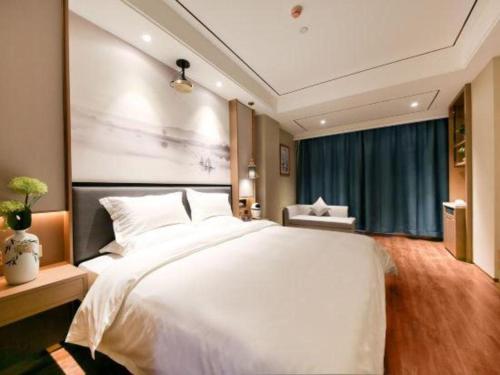 a bedroom with a large white bed and a window at East Queen Hotel (Xi'an Beimen Metro Station) in Xi'an
