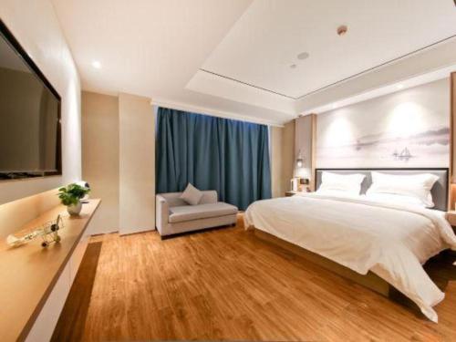 a large bedroom with a large bed and a chair at East Queen Hotel (Xi'an Beimen Metro Station) in Xi'an