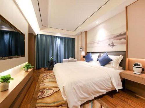 a bedroom with a large white bed and a tv at East Queen Hotel (Xi'an Beimen Metro Station) in Xi'an