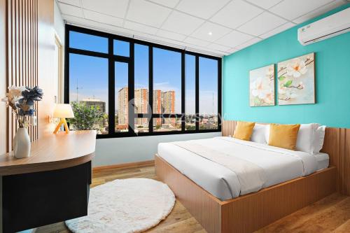 Savya ApartHotel by Kozystay - Bandung City في باندونغ: غرفة نوم بسرير كبير ونافذة كبيرة