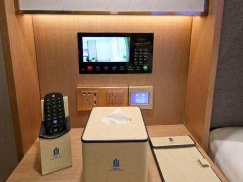 a room with a phone and a tv on the wall at East Queen Hotel (Xi'an Beimen Metro Station) in Xi'an